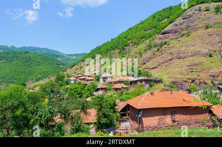 Vista accattivante dei tetti rustici in un antico villaggio di montagna, che mostra un'architettura distintiva e una bellezza naturale. Foto Stock