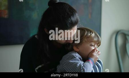 Madre amorevole che tiene giovane ragazzo, mostra affetto materno, genitore culla amorevolmente il figlio in tenero abbraccio Foto Stock