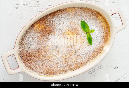 Budino di limone al forno guarnito con zucchero a velo e menta Foto Stock