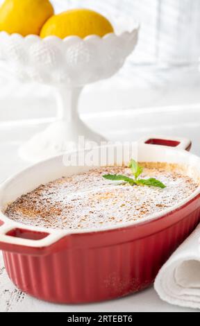 Budino di limone al forno guarnito con zucchero a velo e menta Foto Stock