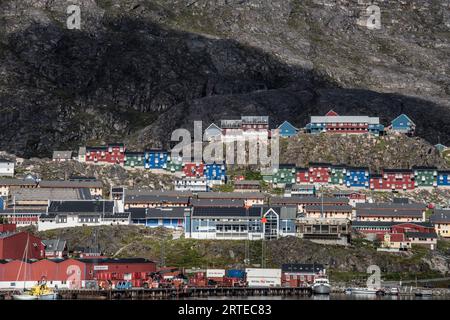 Edifici colorati sulle scogliere rocciose lungo la costa nella città di Qaqortoq sulla punta meridionale della Groenlandia; Qaqortoq, Groenlandia meridionale, Groenlandia Foto Stock