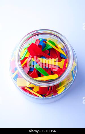 Cucchiai di gelato in plastica colorata in un bicchiere Foto Stock