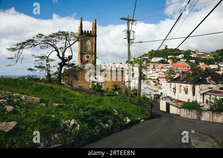 Strada che attraversa la capitale portuale di St Georges con la chiesa presbiteriana di St Andrew (che è stata pesantemente danneggiata nel 2004 dall'uragano Ivan) un... Foto Stock