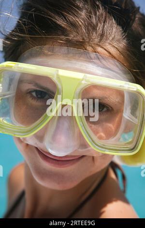 Ritratto ravvicinato di una giovane donna che indossa l'attrezzatura da snorkeling, posa e sorride davanti alla macchina fotografica di Stingray City (un popolare banco di sabbia offshore dove... Foto Stock