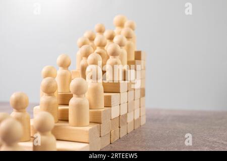 la silhouette di un lavoratore di ufficio con una valigia sale le scale. ingranaggi su uno sfondo di legno Foto Stock