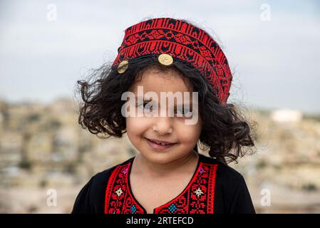 Ritratto di una giovane ragazza giordana in un abbigliamento tradizionale chiamato thawb, Amman, Giordania Foto Stock