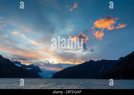 Tramonto sul ghiacciaio Holgate e sulle montagne Kenai, con nuvole accese in una giornata estiva a Holgate Arm, Aialik Bay, Kenai Fjords National Park, al... Foto Stock