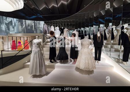 LONDRA, REGNO UNITO - 12 SETTEMBRE 2023: I curatori del museo posa con abiti da sera Chanel esposti su una ricreazione dell'iconica scalinata a specchio basata sull'atelier della designer durante una foto per la prossima mostra Gabrielle Chanel. Fashion Manifesto (16 settembre 2023 - 25 febbraio 2024) al V&A di Londra, Regno Unito il 12 settembre 2023. La prima grande mostra del Regno Unito dedicata al lavoro della pionieristica couturiere francese, Gabrielle "Coco" Chanel, presenterà oltre 200 look visti insieme per la prima volta, oltre ad accessori, profumi e gioielli. (Foto Foto Stock