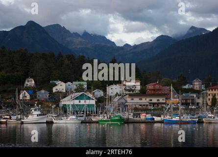 Case e barche nel porto del villaggio di pescatori sull'isola di Baranof a Sitka, Alaska, Stati Uniti; isola di Barnof, Sitka, Alaska, Stati Uniti d'America Foto Stock