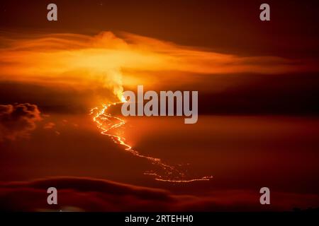 Spettacolare panoramica dell'eruzione del 2022 e del flusso di lava del vulcano Mauna Loa (Moku‘āweoweo, il vulcano attivo più grande del mondo) con un'arancia e ... Foto Stock