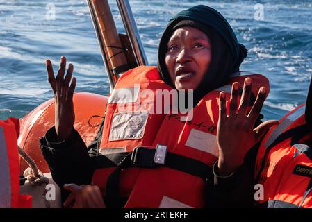 Sar Italia, Italia. 21 febbraio 2023. Una donna si rompe in lacrime e ringrazia Allah pochi minuti dopo essere stata salvata dalla nave di salvataggio della ONG marittima spagnola in sar Italia. Intorno alle 7:30, a 44 km da Lampedusa, 40 migranti subsahariani sono stati salvati da una precaria barca metallica. (Immagine di credito: © Ximena Borrazas/SOPA Images via ZUMA Press Wire) SOLO USO EDITORIALE! Non per USO commerciale! Foto Stock