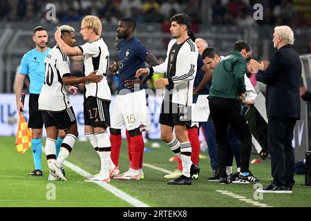 13 settembre 2023, Renania settentrionale-Vestfalia, Dortmund: Calcio: Internazionale, Germania - Francia, Signal Iduna Park. Il team manager ad interim Rudi Völler (r) applaude Serge Gnabry (l) durante la sua sostituzione. I sostituti Julian Brandt (2° da sinistra), Marcus Thuram francese (M) e Kai Havertz tedesco (2° da destra) sono pronti a cambiare. NOTA IMPORTANTE: In conformità alle norme della DFL Deutsche Fußball Liga e della DFB Deutscher Fußball-Bund, è vietato utilizzare o far utilizzare fotografie scattate nello stadio e/o della partita sotto forma di immagini di sequenza e/o video-like pho Foto Stock