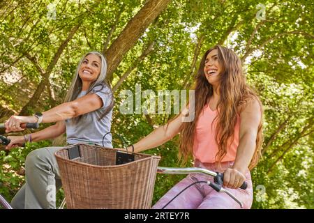 Madre e figlia adulta in bicicletta nel parco Foto Stock