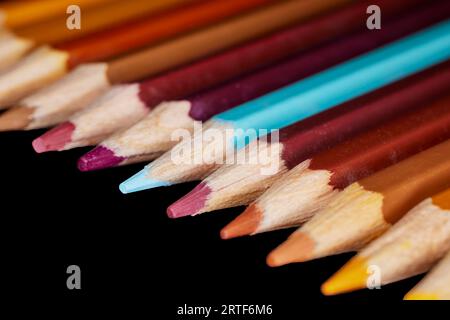 Fila di matite di colore marrone con una matita blu allineata l'una all'altra Foto Stock