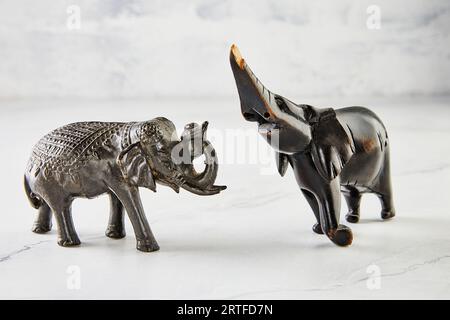 Statuette di elefanti in legno su marmo bianco Foto Stock