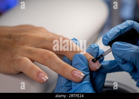 Procedura di cura delle unghie in un salone di bellezza. Mani e strumenti femminili per la manicure, processo di esecuzione della manicure in un salone di bellezza. Concezione spa per il corpo. Glo Foto Stock