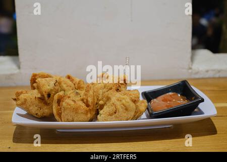 Scatto a fuoco selettivo di un piatto di polpette fritte con salsa al peperoncino Foto Stock