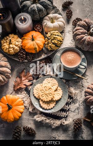 Cioccolata Chai o cacao caldo con biscotti chai e zucche per la colazione del giorno del Ringraziamento. Accogliente natura morta autunnale, hygge. Foto Stock