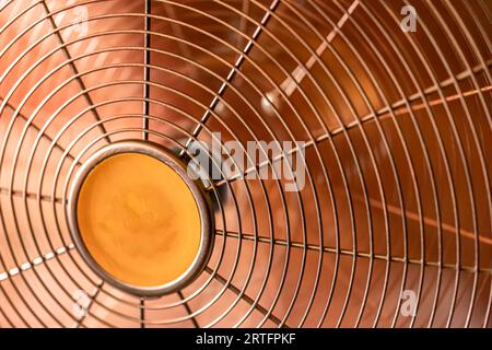 Primo piano che rivela l'intricato design della griglia protettiva di un ventilatore d'epoca. Foto Stock