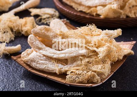 Fungo di Stinkhorn tropicale essiccato, Phallus indusiatus , fungo di bambù essiccato in piatto per uso in hot pot Foto Stock