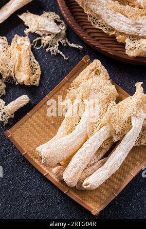 Fungo di Stinkhorn tropicale essiccato, Phallus indusiatus , fungo di bambù essiccato in piatto per uso in hot pot Foto Stock