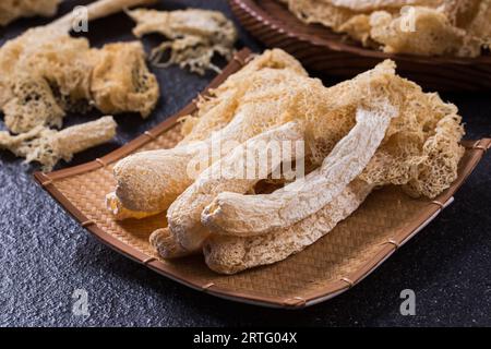 Fungo di Stinkhorn tropicale essiccato, Phallus indusiatus , fungo di bambù essiccato in piatto per uso in hot pot Foto Stock