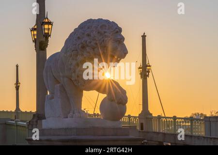 St Augustine, Florida, Stati Uniti d'America - 26 ottobre 2021 - il sole nascente sbircia sulla zampa della statua del leone al Ponte dei leoni di St. Augustine, Florida Foto Stock