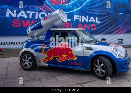 Losanna, Vaud Canton, Svizzera - 20 agosto 2023: Red Bull pubblicità Mini Cooper car con logo. Gigante Red Bull Energy drink sulla roo della macchina Foto Stock