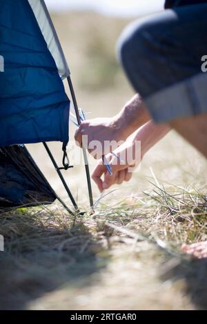 Camper mani il fissaggio palo della tenda Foto Stock