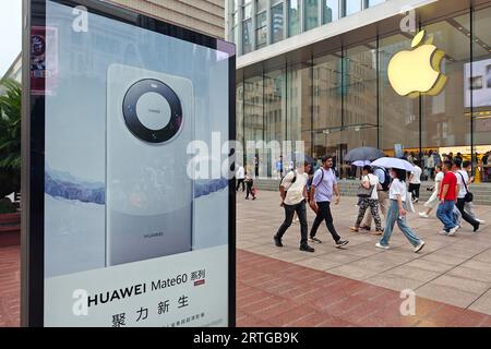 SHANGHAI, CINA - 13 SETTEMBRE 2023 - Una scatola luminosa che pubblicizza il telefono cellulare Huawei Mate 60 è visibile di fronte all'Apple Store in Nanjing Road a Shan Foto Stock