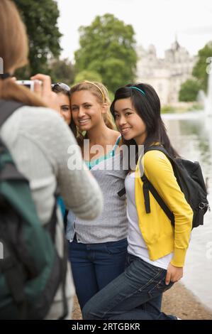 Vista posteriore della donna prendendo fotografia di tre ragazze adolescente Foto Stock