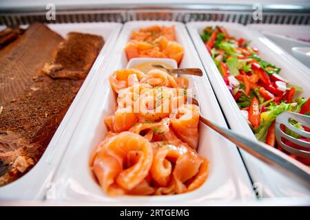 Tradizionale piatto scandinavo salmone gravlax, sale e salmone fresco stagionato con zucchero in un piatto da portata sul tavolo a buffet del ristorante. Foto Stock
