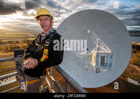 Brett Reid, responsabile dell'Osservatorio su un picchetto di ciliegie sopra il piatto principale dell'ex radiotelescopio UTAS della NASA a Mt Pleasant in Tasmania Foto Stock