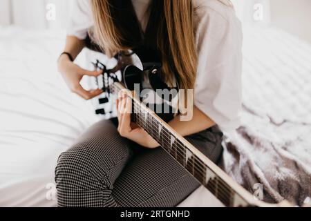 Bruna giovane donna a suonare la chitarra Foto Stock