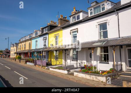 Fila di alloggi terrazzati color pastello sulla strada principale a Portmadoc, Gwynedd, Galles. Foto Stock