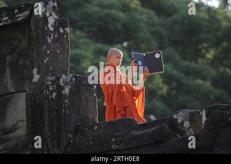 Un giovane Monk che guarda un iPad, Monk che posa con iPad, Young Monk in Cambogia, Monk che fa clic sulle fotografie con iPad Foto Stock