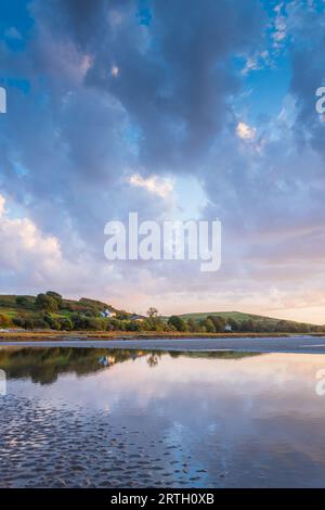 Tramonto a Traeth Bach con cielo blu e mare calmo. Foto Stock