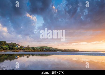 Tramonto a Traeth Bach con cielo blu e mare calmo. Foto Stock