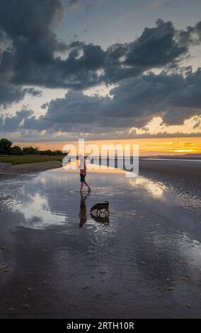 Tramonto a Traeth Bach con cielo blu e mare calmo. Foto Stock