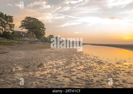 Tramonto a Traeth Bach con cielo blu e mare calmo. Foto Stock