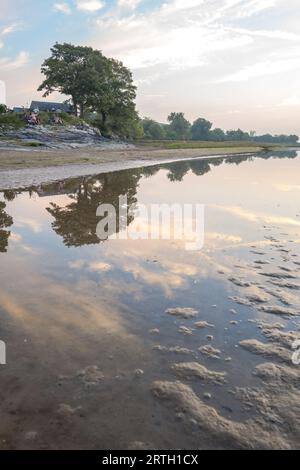 Tramonto a Traeth Bach con cielo blu e mare calmo. Foto Stock