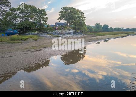 Tramonto a Traeth Bach con cielo blu e mare calmo. Foto Stock