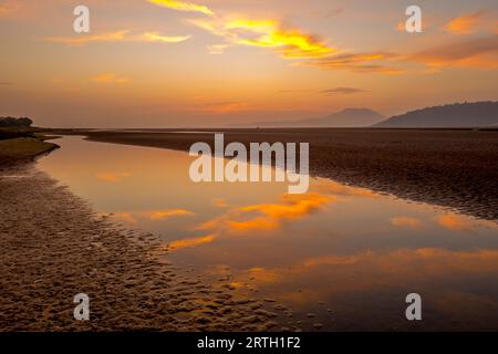 Tramonto a Traeth Bach con cielo blu e mare calmo. Foto Stock