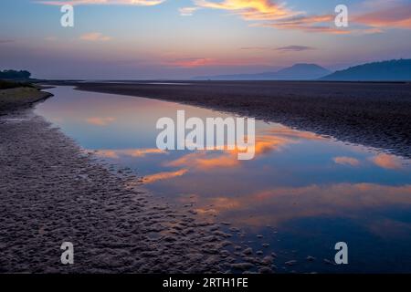 Tramonto a Traeth Bach con cielo blu e mare calmo. Foto Stock