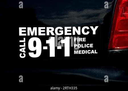 Istruzioni telefoniche di emergenza su un veicolo della polizia bianco e nero degli Stati Uniti Foto Stock