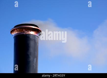 Imbuto del vecchio motore a vapore con vista ravvicinata del fumo contro un cielo blu Foto Stock