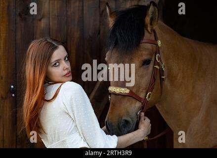 Bella ragazza di campagna in posa con il cavallo nel ranch Foto Stock