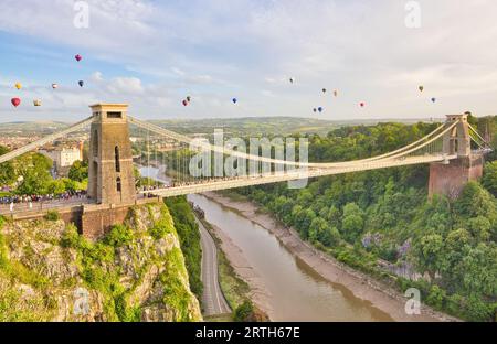 Le mongolfiere dai colori vivaci riempiono l'intera larghezza del cielo mentre sorvolano il ponte sospeso Clifton durante la festa in mongolfiera. Foto Stock