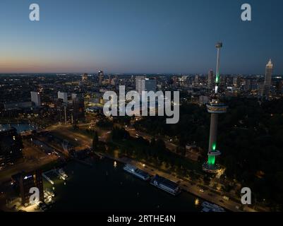 Vista aerea con droni dello skyline di Rotterdam al tramonto, di notte. Euromast, Rotterdam, Paesi Bassi. Foto Stock
