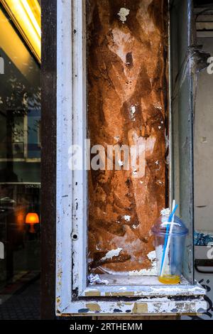 Tazza di plastica abbandonata su uno scaffale in strada in spagna Foto Stock